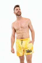 Man wearing yellow swim shorts with text on a white background